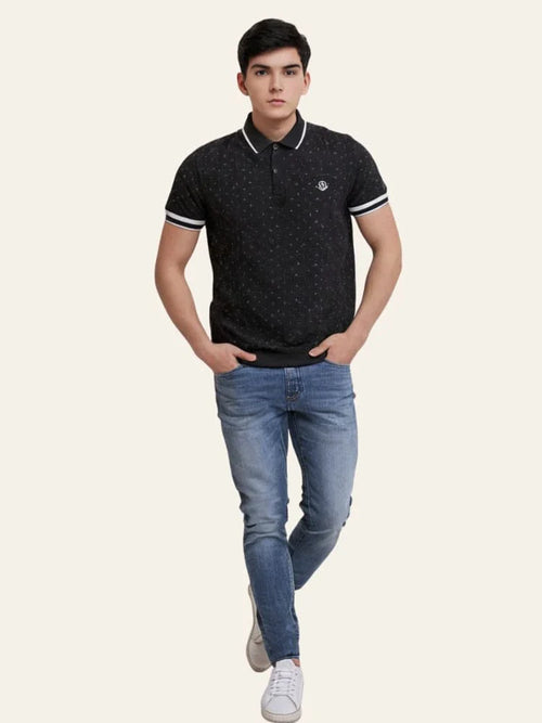 Man wearing a black patterned polo shirt and blue jeans on a white background Black Dotted Regular Fit Men’s Polo T-Shirt Royal Outfits POLO T Shirts
