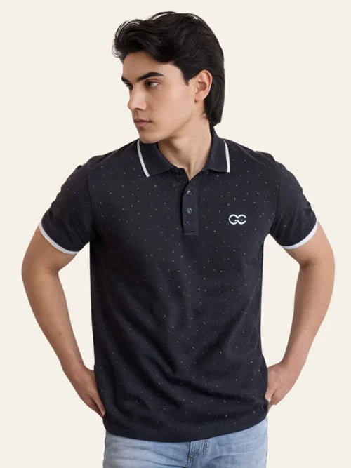 Man wearing a navy blue polo shirt with a logo on a beige background Black Dotted Regular Fit Men’s Polo T-Shirt Royal Outfits POLO T Shirts - Black Dotted Regular Fit Men’s Polo T-Shirt - Royal Outfits - POLO T Shirts - Black Dotted Regular Fit Men’s Polo T-Shirt - Royal Outfits