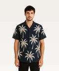 Man wearing a navy blue shirt with palm tree pattern on a white background Black Shirt with Golden Palm Print Royal Outfits Printed Shirts - Black Shirt with Golden Palm Print - Royal Outfits - Printed Shirts - Black Shirt with Golden Palm Print - Royal Outfits
