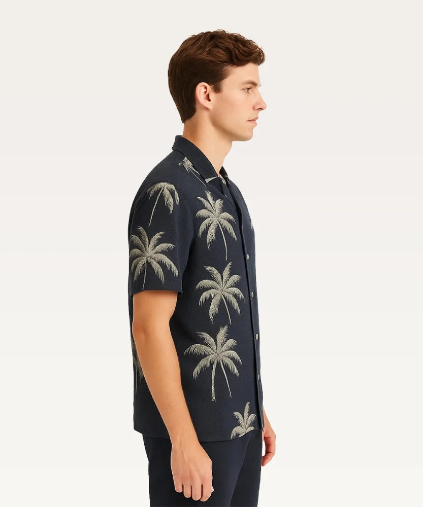 Man wearing a dark blue shirt with palm tree patterns on a white background Black Shirt with Golden Palm Print Royal Outfits Printed Shirts - Black Shirt with Golden Palm Print - Royal Outfits - Printed Shirts - Black Shirt with Golden Palm Print - Royal Outfits