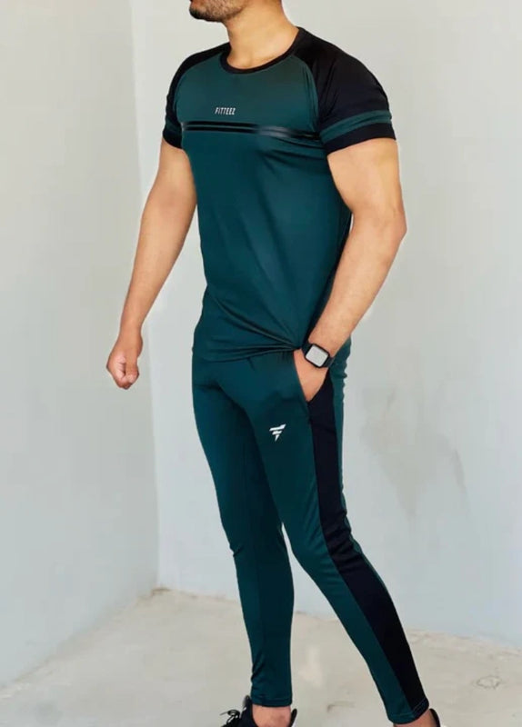 Person wearing a green and black athletic outfit with a visible brand logo on a plain background Pro-Fit Track Suit Royal Outfits Track Suits