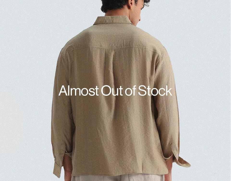 A man wearing beige colour shirt posing backside on white colour background
