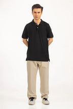 Man wearing a black polo shirt and beige pants on a white background Black Regular Fit Men POLO T-Shirt Royal Outfits POLO T Shirts