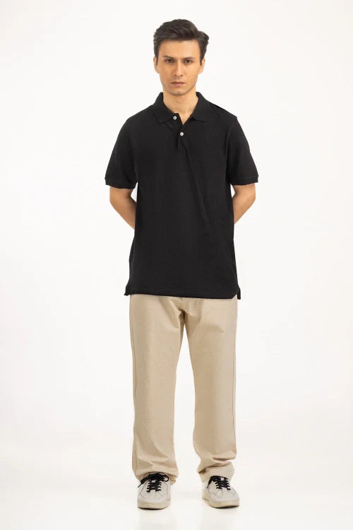 Man wearing a black polo shirt and beige pants on a white background Black Regular Fit Men POLO T-Shirt Royal Outfits POLO T Shirts