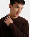 Man wearing a brown sweater against a plain background