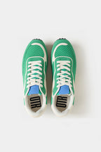 Green sneakers with white laces on a light gray background