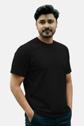Man wearing a black t-shirt against a plain background Plain Colourful T-Shirt Royal Outfits Plain T-Shirts