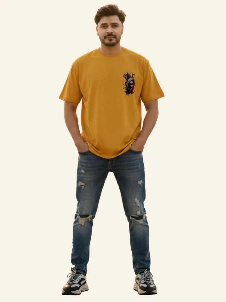 Man wearing a mustard yellow t-shirt with a graphic design and blue jeans on a plain background Graphic Mustard/Yellow Drop Shoulder Axe Man T-Shirt Royal Outfits Drop Shoulder T-Shirts
