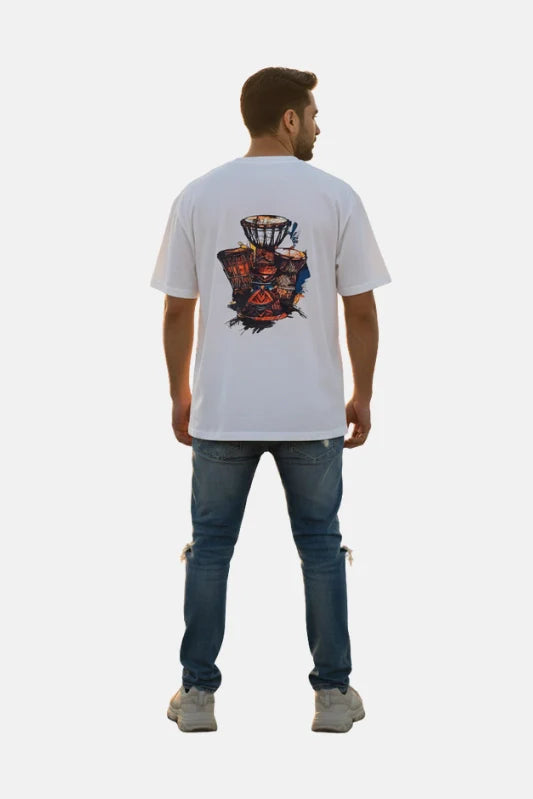 Man wearing a white t-shirt with a colorful design on the back, standing against a plain background. Graphic White Drop Shoulder "Dhool" T-Shirt Royal Outfits Drop Shoulder T-Shirts - Graphic White Drop Shoulder "Dhool" T-Shirt - Royal Outfits - Drop Shoulder T-Shirts