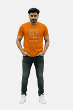 Man wearing an orange t-shirt with text design on a plain background Graphic Orange Crossword T-Shirt Royal Outfits Graphic T Shirts - Graphic Orange Crossword T-Shirt - Royal Outfits - Graphic T Shirts - Graphic Orange Crossword T-Shirt - Royal Outfits