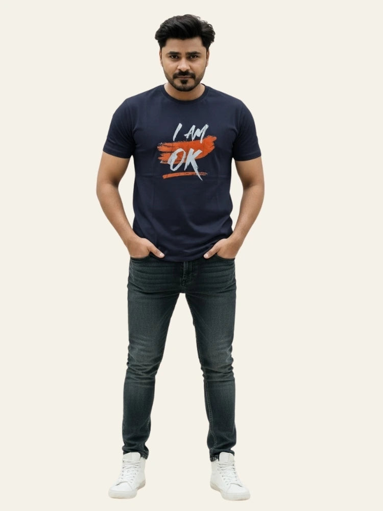 Man wearing a navy blue t-shirt with 'I AM OK' text and dark jeans on a light gray background Graphic Navy Blue "I'M OK" T-Shirt Royal Outfits Graphic T Shirts