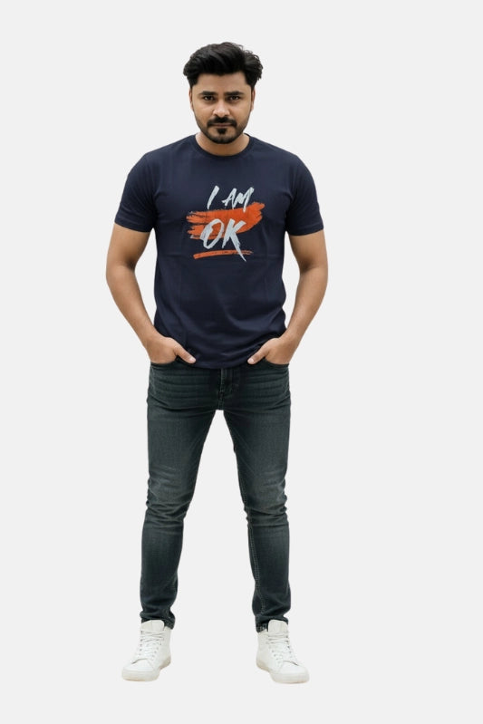 Man wearing a navy blue t-shirt with 'I AM OK' text and dark jeans on a light gray background Graphic Navy Blue "I'M OK" T-Shirt Royal Outfits Graphic T Shirts - Graphic Navy Blue "I'M OK" T-Shirt - Royal Outfits - Graphic T Shirts - Graphic Navy Blue "I'M OK" T-Shirt - Royal Outfits