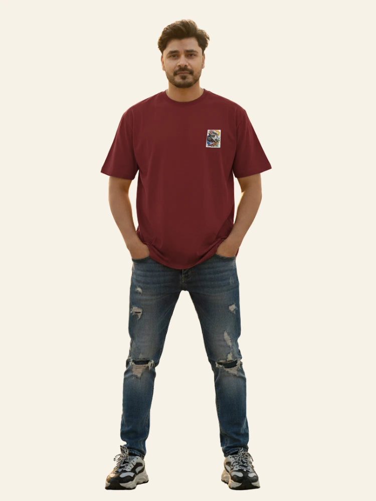 Man wearing a red t-shirt and blue jeans on a plain background Graphic Maroon Drop Shoulder King Ace T-Shirt Royal Outfits Drop Shoulder T-Shirts