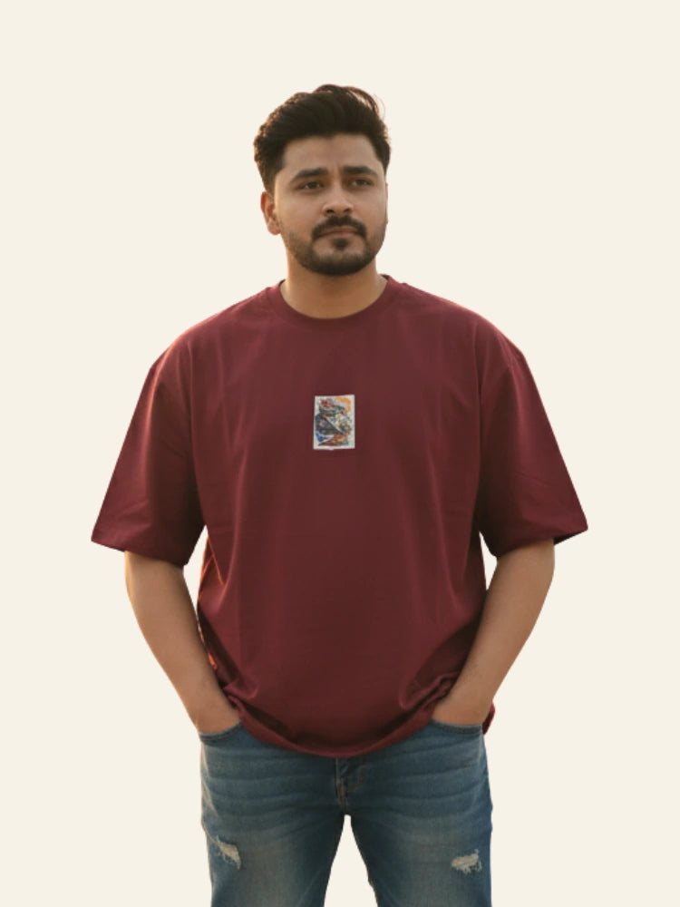 Man wearing a maroon t-shirt with a small graphic on a plain background Graphic Maroon Drop Shoulder King Ace T-Shirt Royal Outfits Drop Shoulder T-Shirts