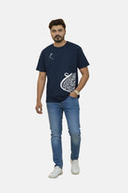 Man wearing a navy blue t-shirt with a white graphic design and blue jeans on a beige background Graphic Navy Blue Drop Shoulder Calligraphy T-Shirt Royal Outfits Drop Shoulder T-Shirts - Graphic Navy Blue Drop Shoulder Calligraphy T-Shirt - Royal Outfits - Drop Shoulder T-Shirts