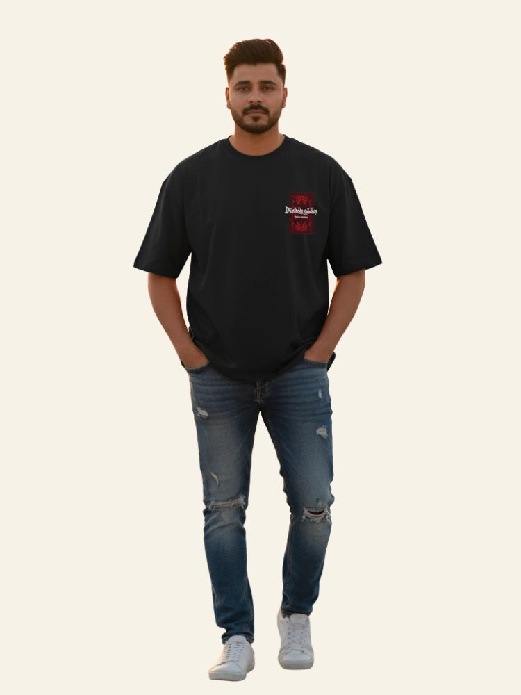 Man wearing a black t-shirt with a red logo and blue jeans on a white background Graphic Black Drop Shoulder Dimension T-Shirt Royal Outfits Drop Shoulder T-Shirts