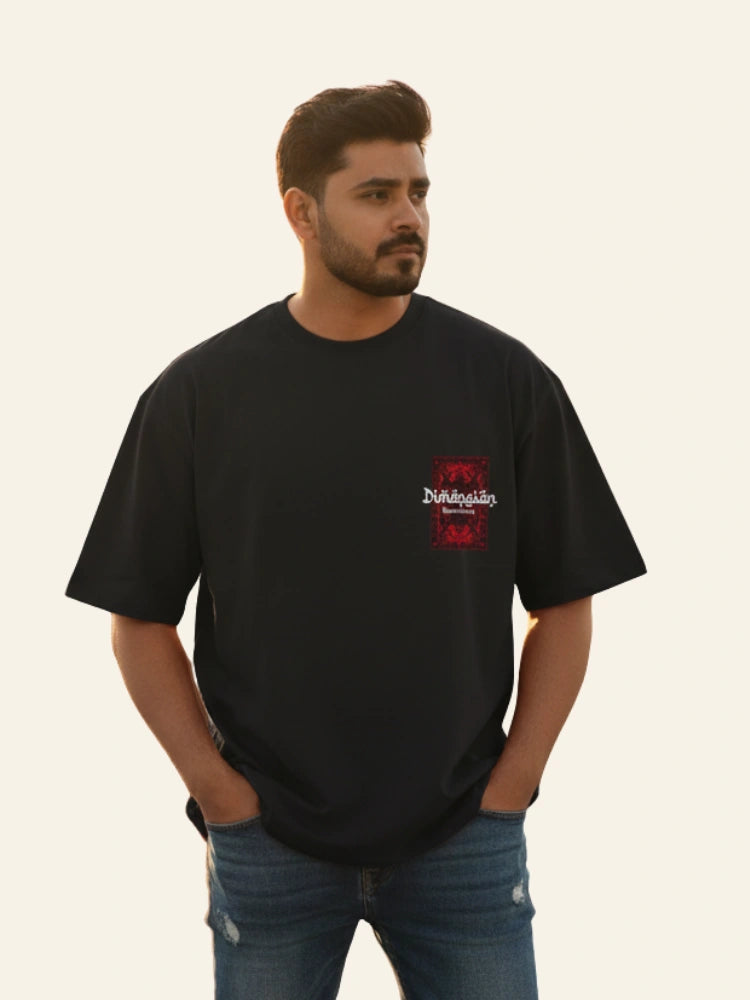 Man wearing a black t-shirt with a logo on a plain background Graphic Black Drop Shoulder Dimension T-Shirt Royal Outfits Drop Shoulder T-Shirts