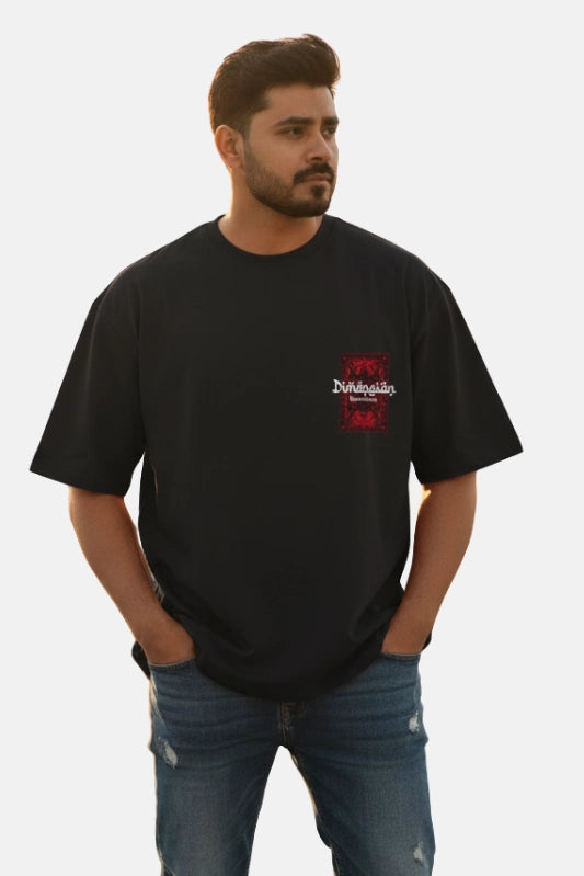 Man wearing a black t-shirt with a logo on a plain background Graphic Black Drop Shoulder Dimension T-Shirt Royal Outfits Drop Shoulder T-Shirts - Graphic Black Drop Shoulder Dimension T-Shirt - Royal Outfits - Drop Shoulder T-Shirts