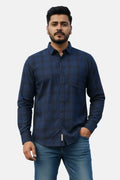 Man wearing a blue checkered shirt against a plain background