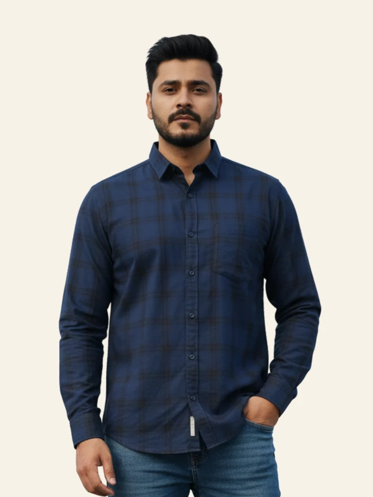 Man wearing a blue checkered shirt against a plain background