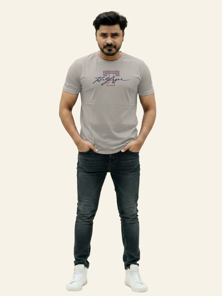 Man wearing a gray t-shirt with a logo and dark jeans on a white background Light Grey T Hedges T-Shirt Royal Outfits Printed T Shirts