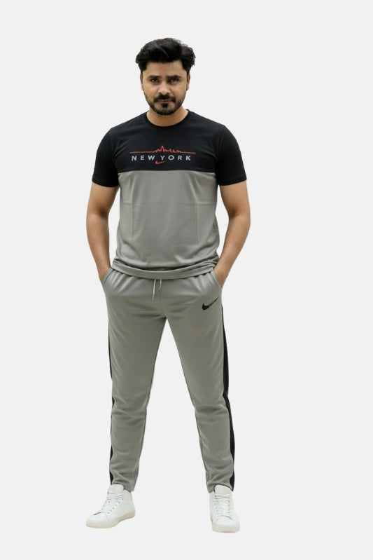 Man wearing a black and gray tracksuit with 'New York' text on a beige background Light Grey ‘New York’ Tracksuit Royal Outfits Track Suits - Light Grey ‘New York’ Tracksuit - Royal Outfits - Track Suits
