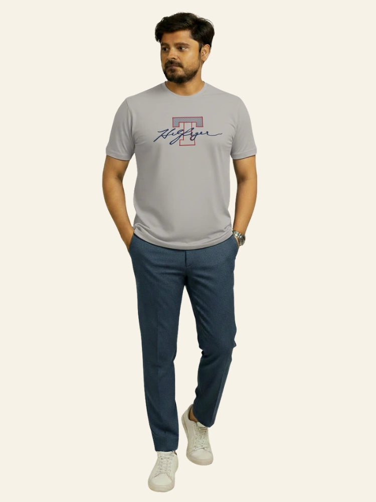 Man wearing a gray t-shirt with a logo and dark blue pants on a white background Light Grey T Hedges T-Shirt Royal Outfits Printed T Shirts