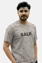 Man wearing a gray t-shirt with 'BALR.' branding on a plain background Light Grey ‘BALR’ T-Shirt Royal Outfits Graphic T Shirts - Light Grey ‘BALR’ T-Shirt - Royal Outfits - Graphic T Shirts - Light Grey ‘BALR’ T-Shirt - Royal Outfits