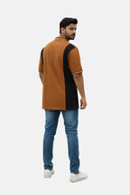 Man wearing a brown and black polo shirt with blue jeans on a beige background - Men’s USPA Brown Colour Contrast Panel Polo T-Shirt - Royal Outfits - POLO T Shirts - Men’s USPA Brown Colour Contrast Panel Polo T-Shirt - Royal Outfits