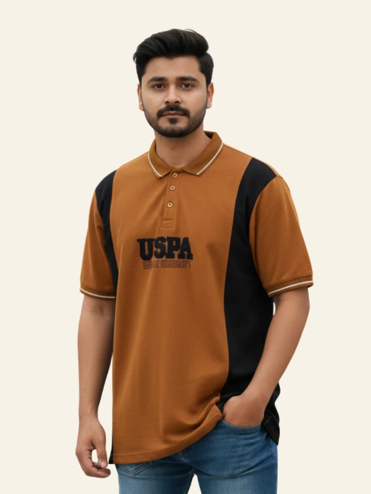 Man wearing a brown and black polo shirt with 'USPA' branding on a beige background