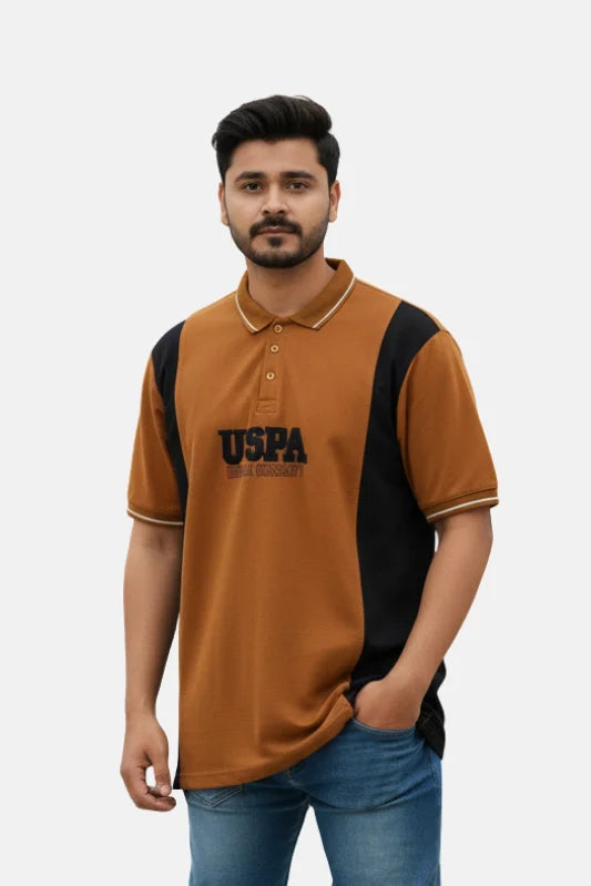 Man wearing a brown and black polo shirt with 'USPA' branding on a beige background - Men’s USPA Brown Colour Contrast Panel Polo T-Shirt - Royal Outfits - POLO T Shirts - Men’s USPA Brown Colour Contrast Panel Polo T-Shirt - Royal Outfits