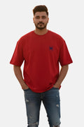 Man wearing a red t-shirt with a small logo on a plain background Graphic Red Drop Shoulder Spider T-Shirt Royal Outfits Drop Shoulder T-Shirts