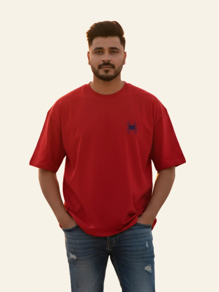 Man wearing a red t-shirt with a small logo on a plain background Graphic Red Drop Shoulder Spider T-Shirt Royal Outfits Drop Shoulder T-Shirts