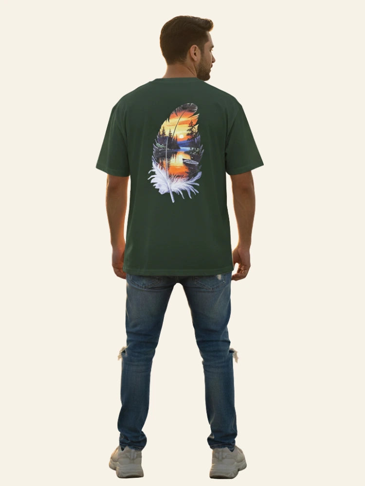 Man wearing a green t-shirt with a nature-themed design on the back, standing against a white background. Graphic Green Drop Shoulder Feather T-Shirt Royal Outfits Drop Shoulder T-Shirts