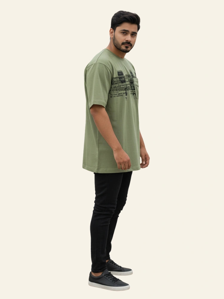 Man wearing a green t-shirt and black pants on a white background