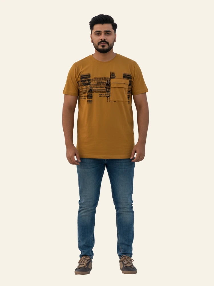 Man wearing a mustard t-shirt with text and blue jeans on a white background