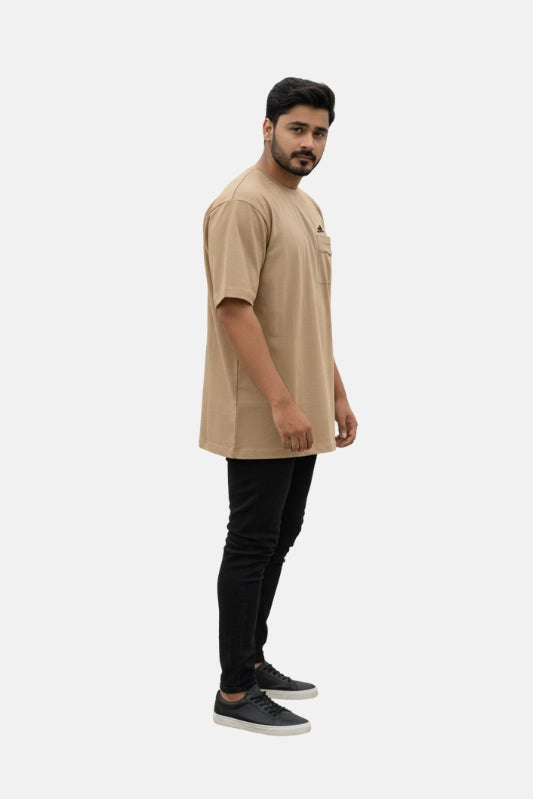 Man wearing a beige long-sleeve shirt and black pants on a white background - Graphic Beige Drop Shoulder T-Shirt with Adidas Logo - Royal Outfits - Drop Shoulder T-Shirts - Graphic Beige Drop Shoulder T-Shirt with Adidas Logo - Royal Outfits
