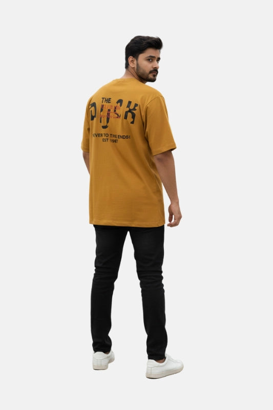Man wearing a mustard yellow t-shirt with text on the back, standing against a white background - Graphic Mustard Drop Shoulder The Duck T-Shirt - Royal Outfits - Drop Shoulder T-Shirts - Graphic Mustard Drop Shoulder The Duck T-Shirt - Royal Outfits