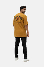 Man wearing a mustard yellow t-shirt with text on the back, standing against a white background - Graphic Mustard Drop Shoulder The Duck T-Shirt - Royal Outfits - Drop Shoulder T-Shirts - Graphic Mustard Drop Shoulder The Duck T-Shirt - Royal Outfits