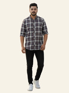Man wearing a checkered shirt, black pants, and white sneakers on a plain background