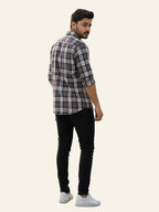 Man wearing a plaid shirt and black pants on a white background