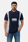 Man wearing a navy blue polo shirt with 'USPA' branding on a beige background - Men’s Black USPA Contrast Panel Polo T-Shirt - Royal Outfits - POLO T Shirts - Men’s Black USPA Contrast Panel Polo T-Shirt - Royal Outfits