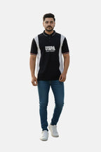 Man wearing a black and white polo shirt with 'USPA' branding on a white background - Men’s Black USPA Contrast Panel Polo T-Shirt - Royal Outfits - POLO T Shirts - Men’s Black USPA Contrast Panel Polo T-Shirt - Royal Outfits
