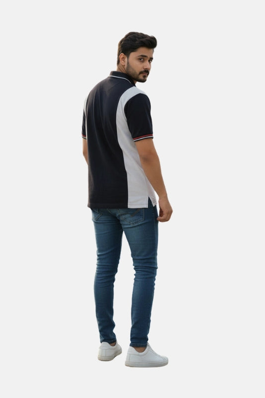 Man wearing a black and white polo shirt with blue jeans on a light gray background - Men’s Black USPA Contrast Panel Polo T-Shirt - Royal Outfits - POLO T Shirts - Men’s Black USPA Contrast Panel Polo T-Shirt - Royal Outfits