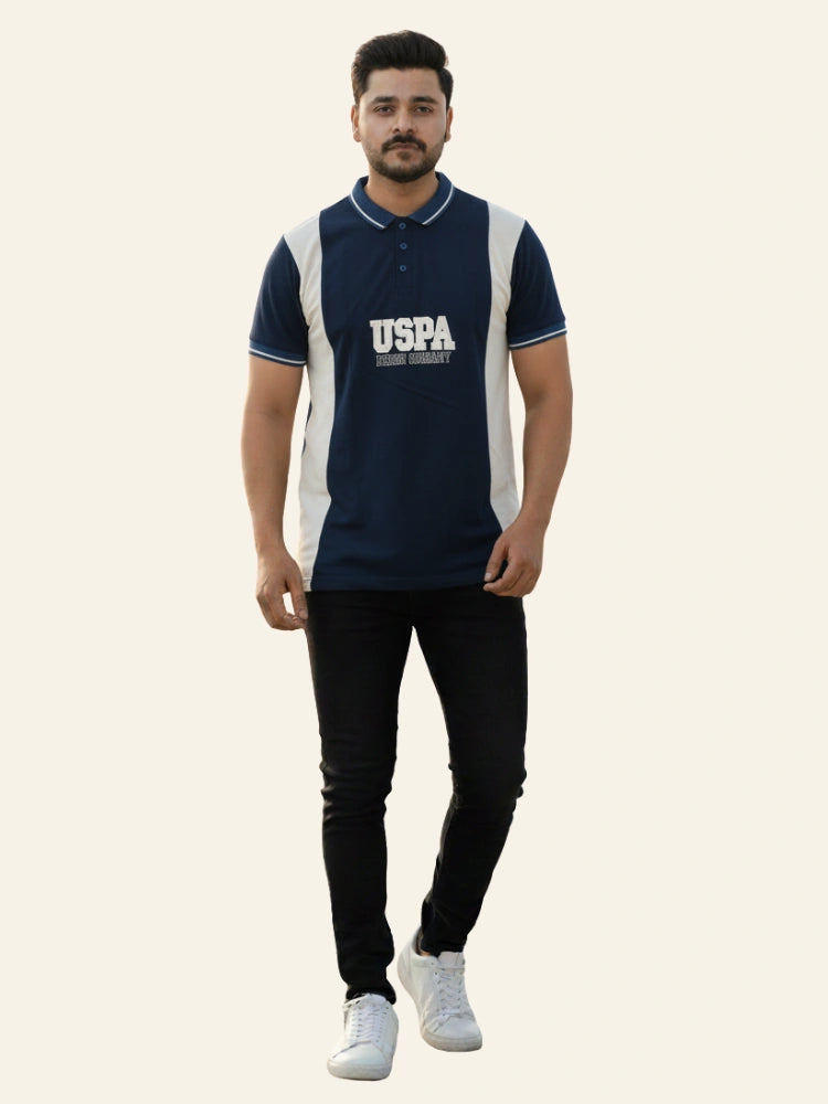 Man wearing a navy blue and white polo shirt with 'USPA' branding on a beige background