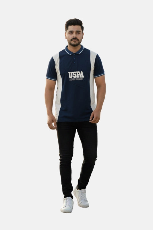 Man wearing a navy blue and white polo shirt with 'USPA' branding on a beige background - Men’s Navy Blue USPA Contrast Panel Polo T-Shirt - Royal Outfits - POLO T Shirts - Men’s Navy Blue USPA Contrast Panel Polo T-Shirt - Royal Outfits