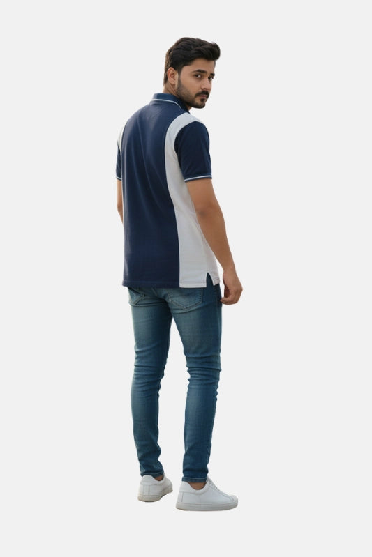 Man wearing a navy and white polo shirt with blue jeans on a beige background - Men’s Navy Blue USPA Contrast Panel Polo T-Shirt - Royal Outfits - POLO T Shirts - Men’s Navy Blue USPA Contrast Panel Polo T-Shirt - Royal Outfits