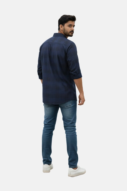 Man wearing a navy blue shirt and jeans on a beige background - Men’s Royal Blue Check Shirt - Royal Outfits - Check Shirts - Men’s Royal Blue Check Shirt - Royal Outfits