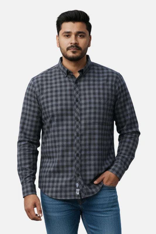 Man wearing a gray checkered shirt and blue jeans on a beige background - Men’s Casual Slim Fit Plaid Shirt – Dark Grey & Black Checked Cotton Button-Up - Royal Outfits - Printed Shirts - Men’s Casual Slim Fit Plaid Shirt – Dark Grey & Black Checked Cotton Button-Up - Royal Outfits