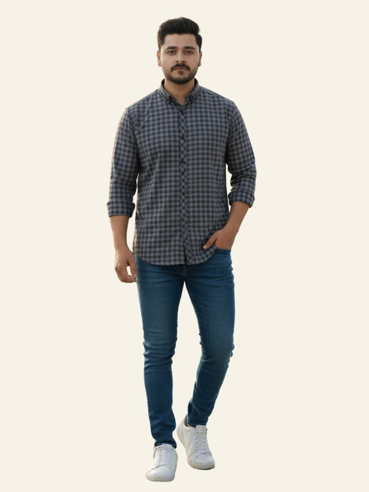 Man wearing a checkered shirt and jeans on a white background